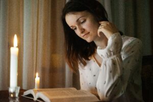 Person reading a love story book in a cozy setting.